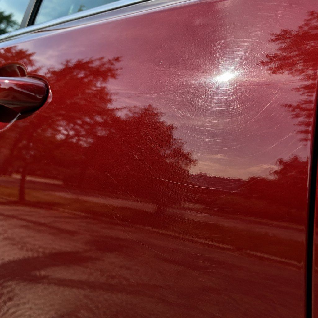 Illustration: swirl marks in the clear coat of a red car door